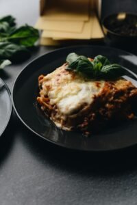 Mouth-watering lasagna topped with fresh basil, capturing the essence of Italian cuisine.